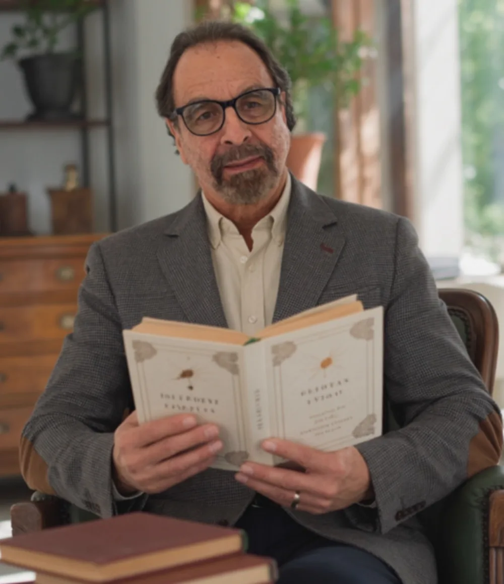 Juan Pablo Ochoa with a stack of his books