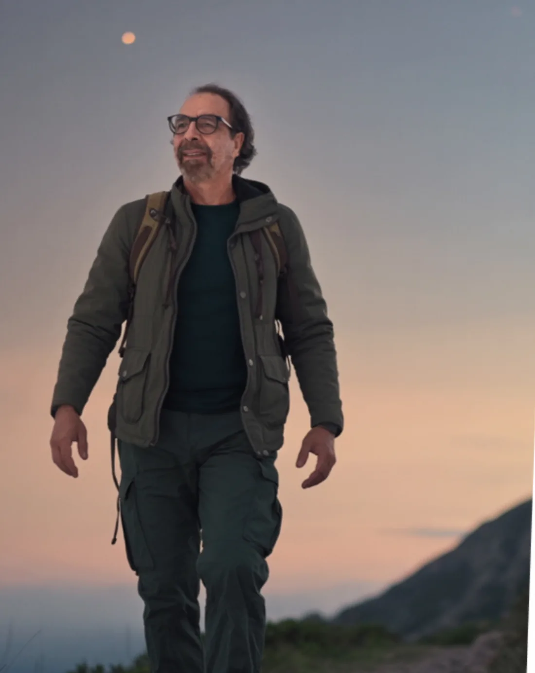 Juan Pablo Ochoa walking a mountain path at dusk
